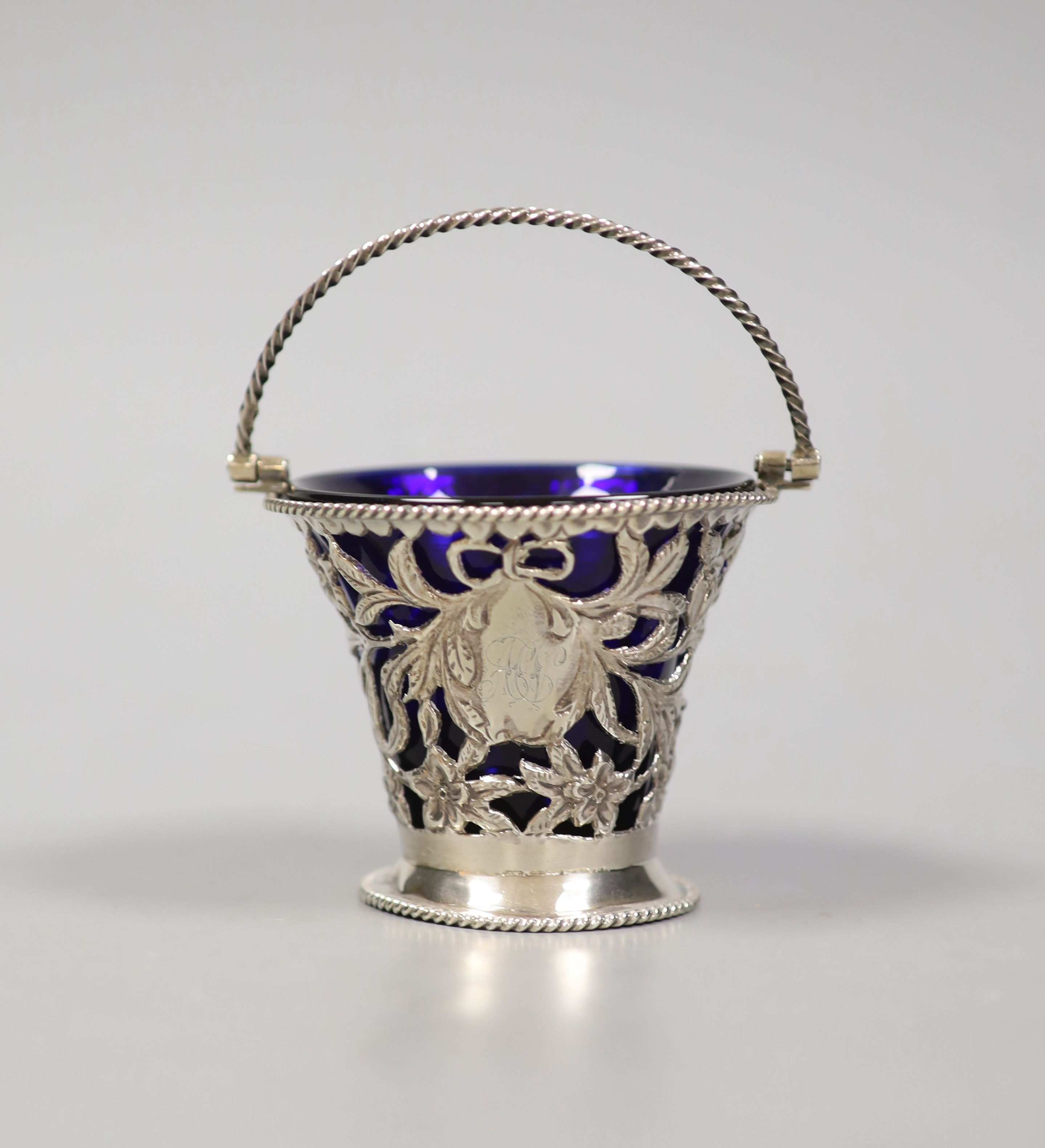 A late Victorian pierced pale-shaped small sugar basket, with cobalt glass liner, William Henry Skinner, London, 1899, height 67mm.